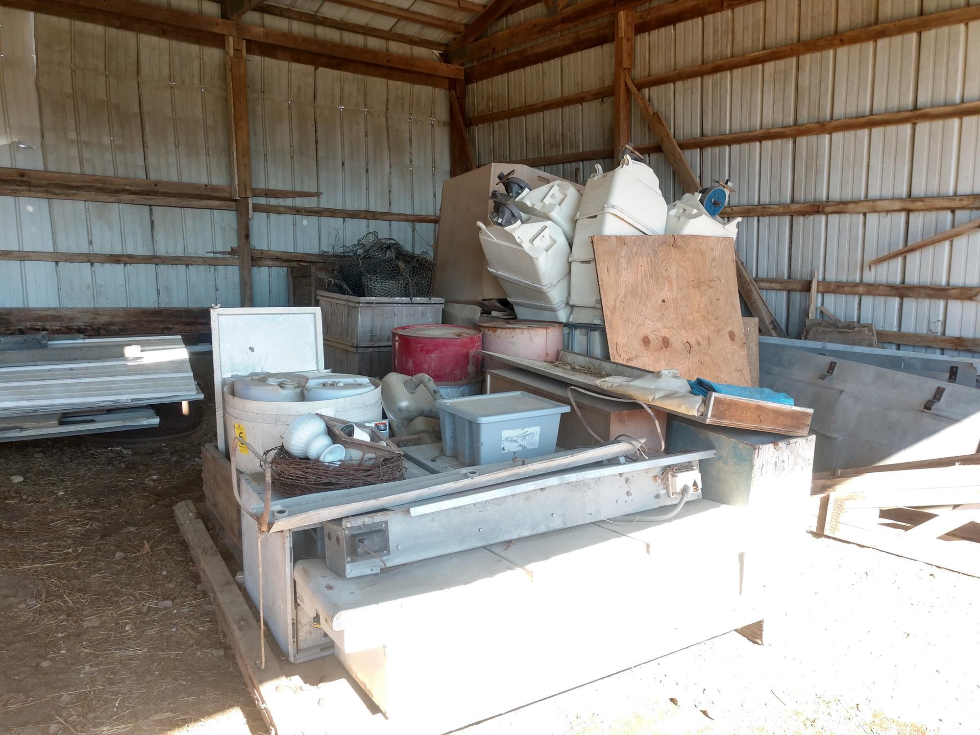 Open shed contents (scrap iron, truck toolbox, old JCB diesel engine in cr