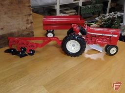 Ertl International die cast tractor, two blade plow, and flare box wagon. 3 pieces