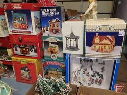 Metal folding table with Holiday items: lighted village pieces with accessories, and ornaments.