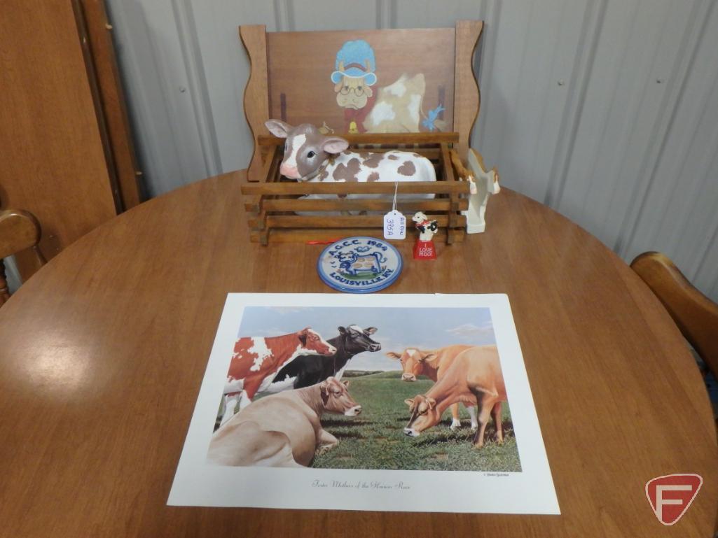 Cow items, print, napkin holder, ceramic figurines, cow bell, and wall decoration. All cow items on