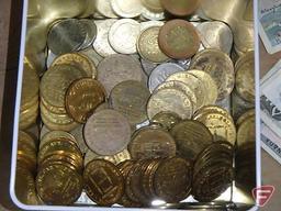 Metal tin of foreign currency and car wash tokens