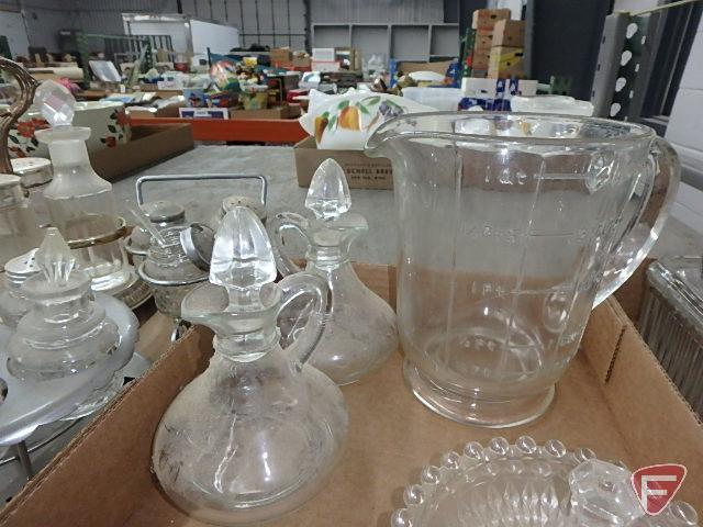 Clear glass condiment sets in metal holders and on glass trays, measuring cup, refrigerator dishes.