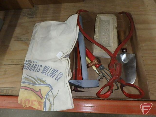 Ice tongs, one Chaska brick, garden tools, hose nozzle, stained Glencoe feed sack