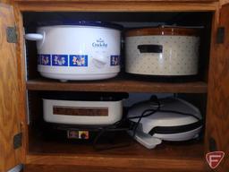 (2) Rival crock pots, West Bend cooker, George Foreman grill machine. All in bottom cupboard