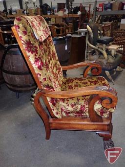 Vintage upholstered reclining chair with carved face arms