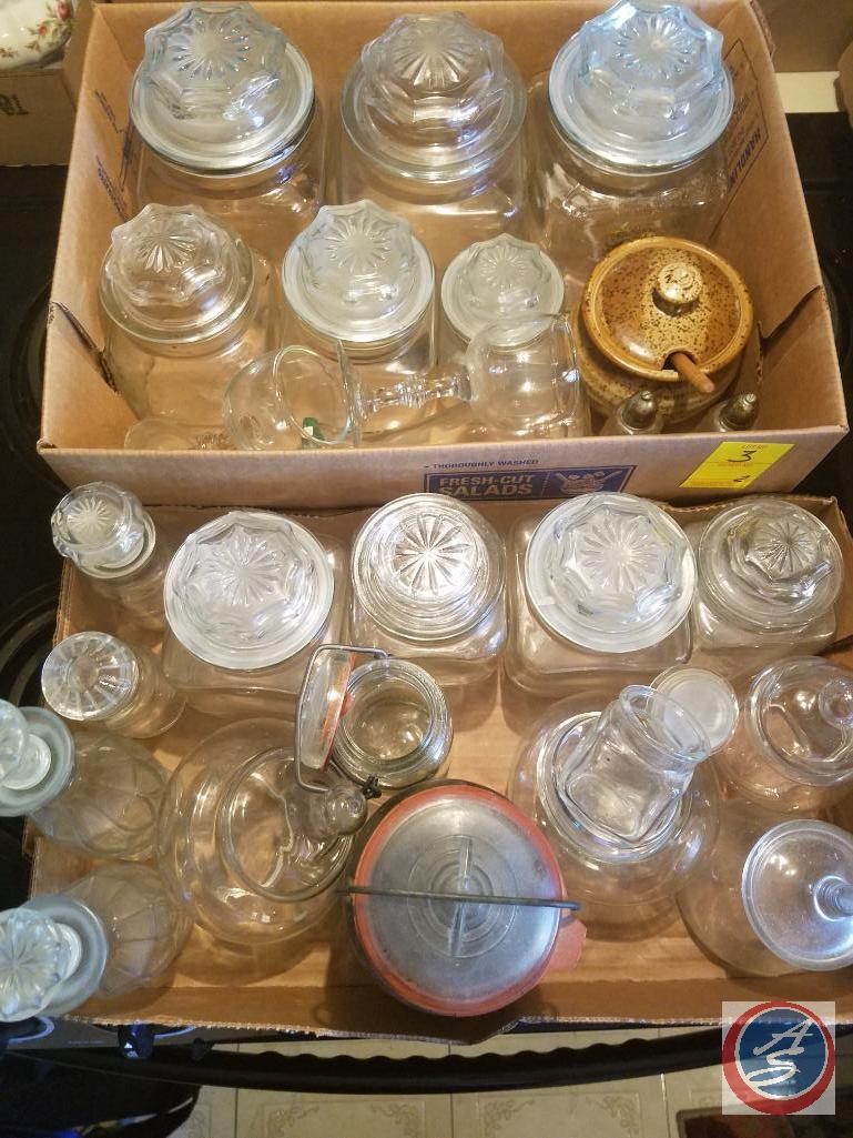 (2) Flats containing an assortment of glass jars with lids, ceramic jar with lid, salt and pepper