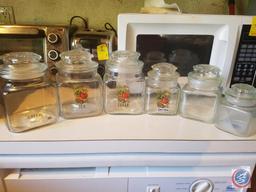 (2) Flats containing an assortment of glass jars with lids, ceramic jar with lid, salt and pepper