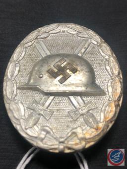 German World War II Silver Wound Badge. The front shows a German helmet in the center with a pair of