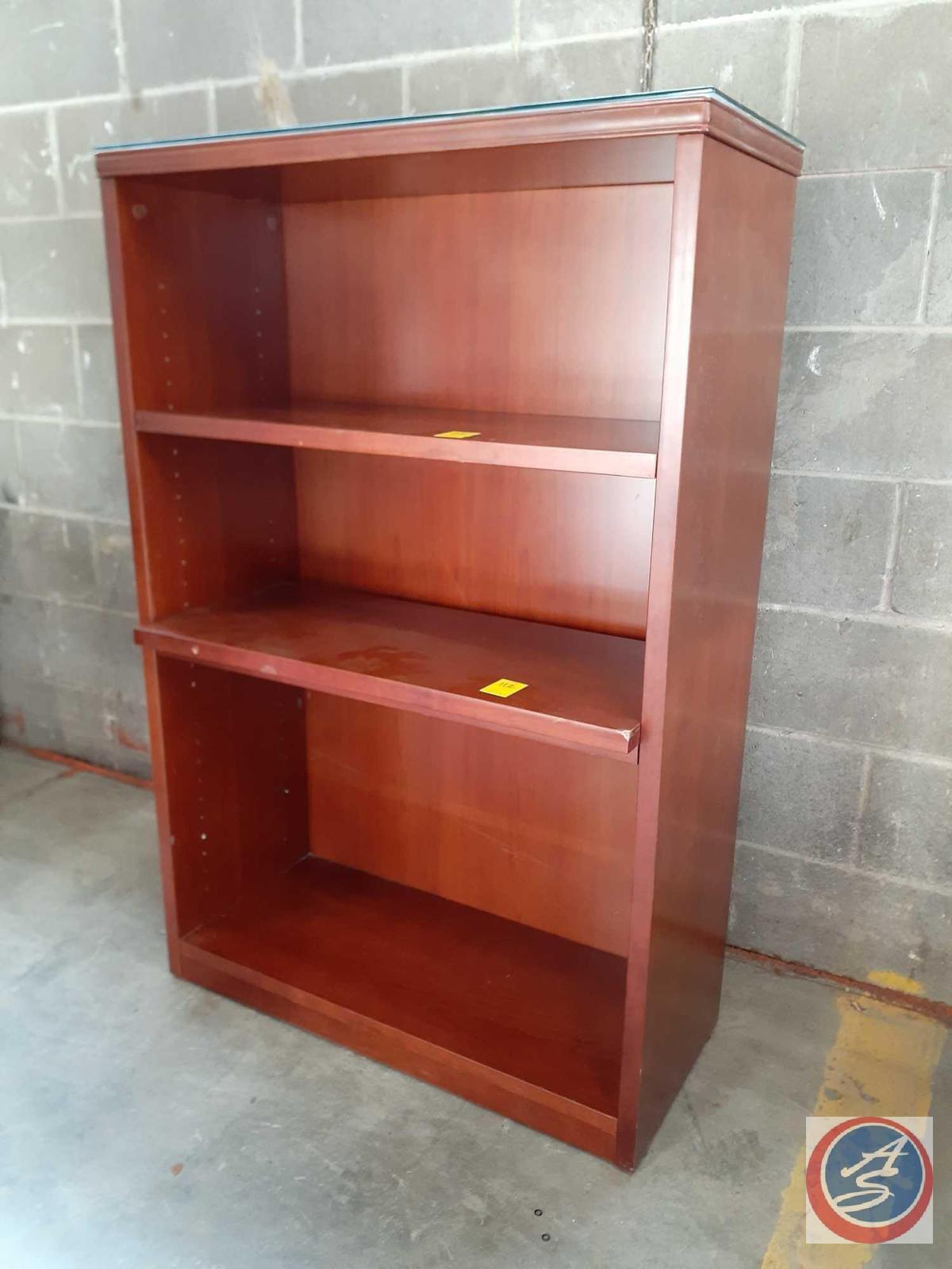 wood bookcase with four shelves (three are adjustable). The back of the bookcase appears to be