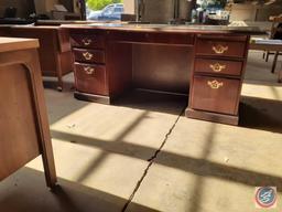 Wood desk with glass top and three drawers on the left, three drawers on the right, and a pencil