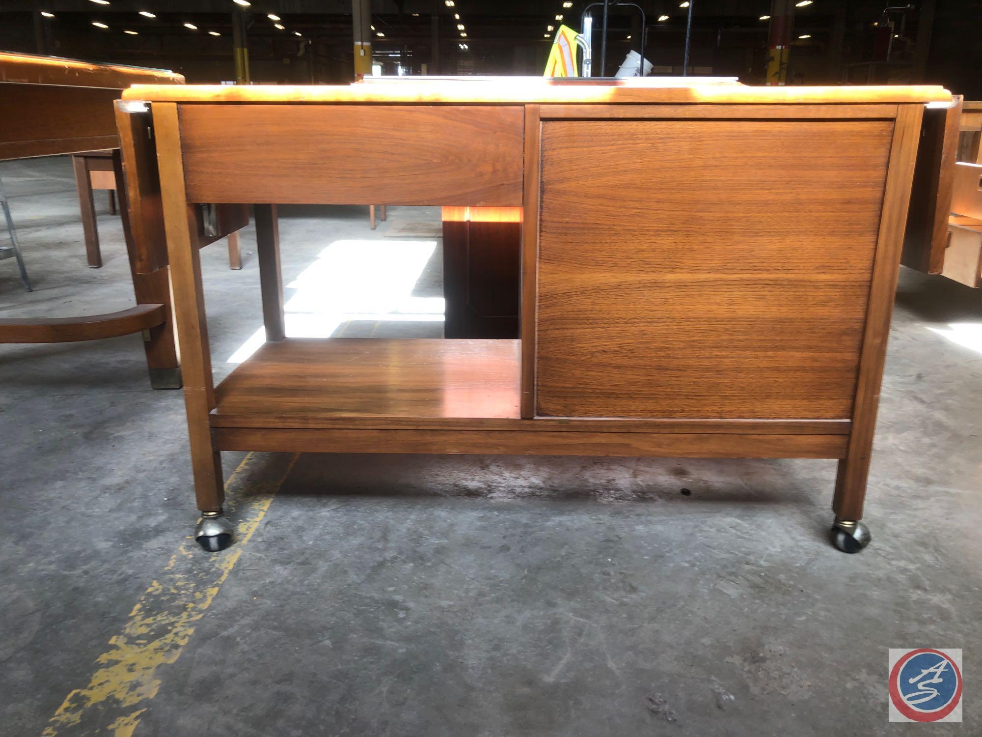 Antique / vintage wood stand on wheels. The stand has one cabinet door on the left and one drawer