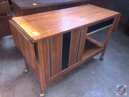 Antique / vintage wood stand on wheels. The stand has one cabinet door on the left and one drawer