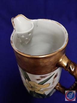 Hand-painted porcelain coffee pitcher. Daffodil design, gold trim. H 8? (Mark: A.M.N. 89)