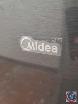 Midea Mini-fridge with reversible door. There are glass shelves as well as a top freezer space.