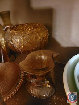 Assorted amber colored glass items. Items include Chicken covered basket, and vases. There are