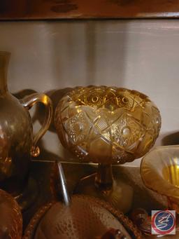 Assorted amber colored glass items. Items include Chicken covered basket, and vases. There are