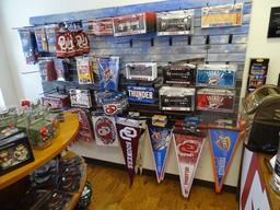 BANNERS ON WALL 12 PCS, LICENSE PLATES & HOLDERS 100+, PENNANTS 90+, KOOZIES 9. FLAGS 21,