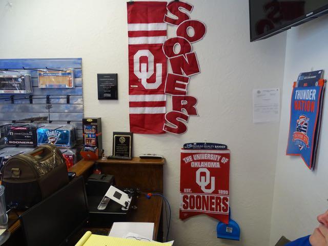 BANNERS ON WALL 12 PCS, LICENSE PLATES & HOLDERS 100+, PENNANTS 90+, KOOZIES 9. FLAGS 21,