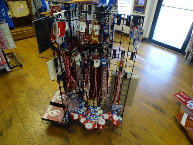 BANNERS ON WALL 12 PCS, LICENSE PLATES & HOLDERS 100+, PENNANTS 90+, KOOZIES 9. FLAGS 21,