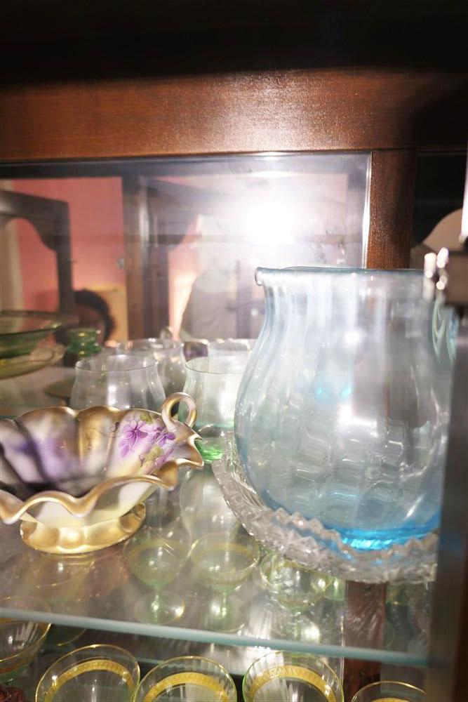 Top two shelves of antique glass in cabinet