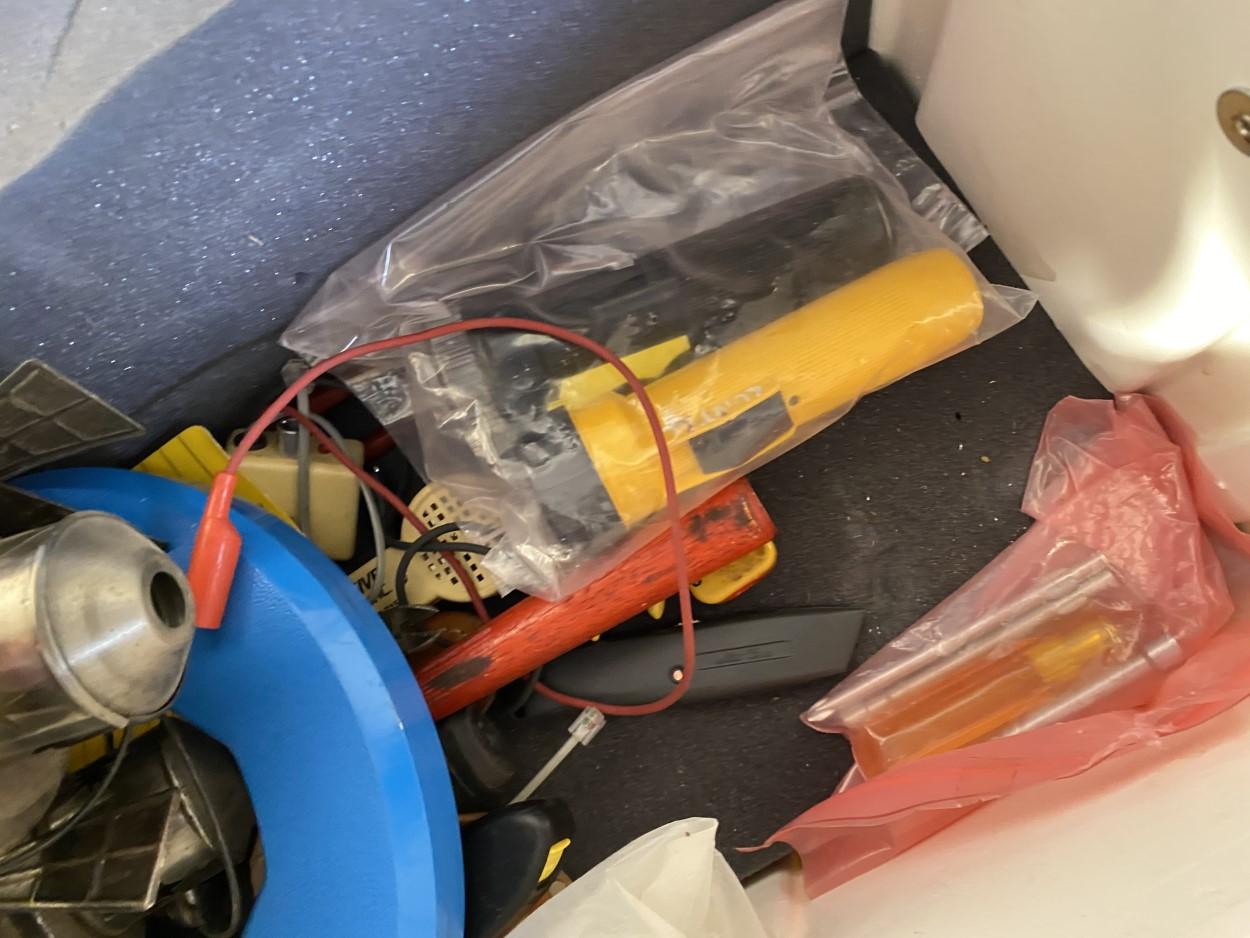 Plastic utility case filled with assorted items and tools