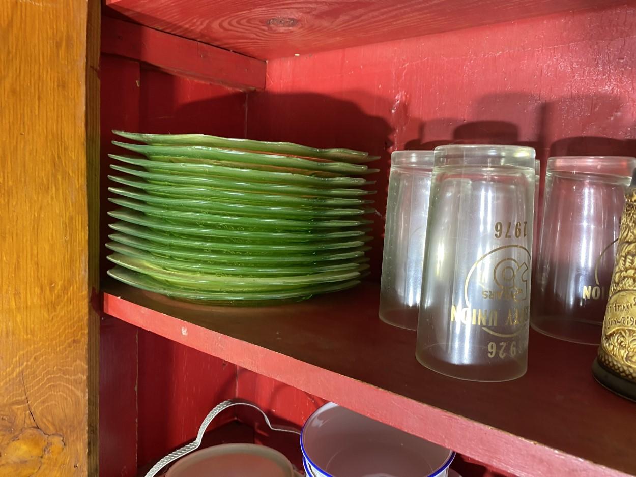 Cupboard lot including stack of green depression glass plates