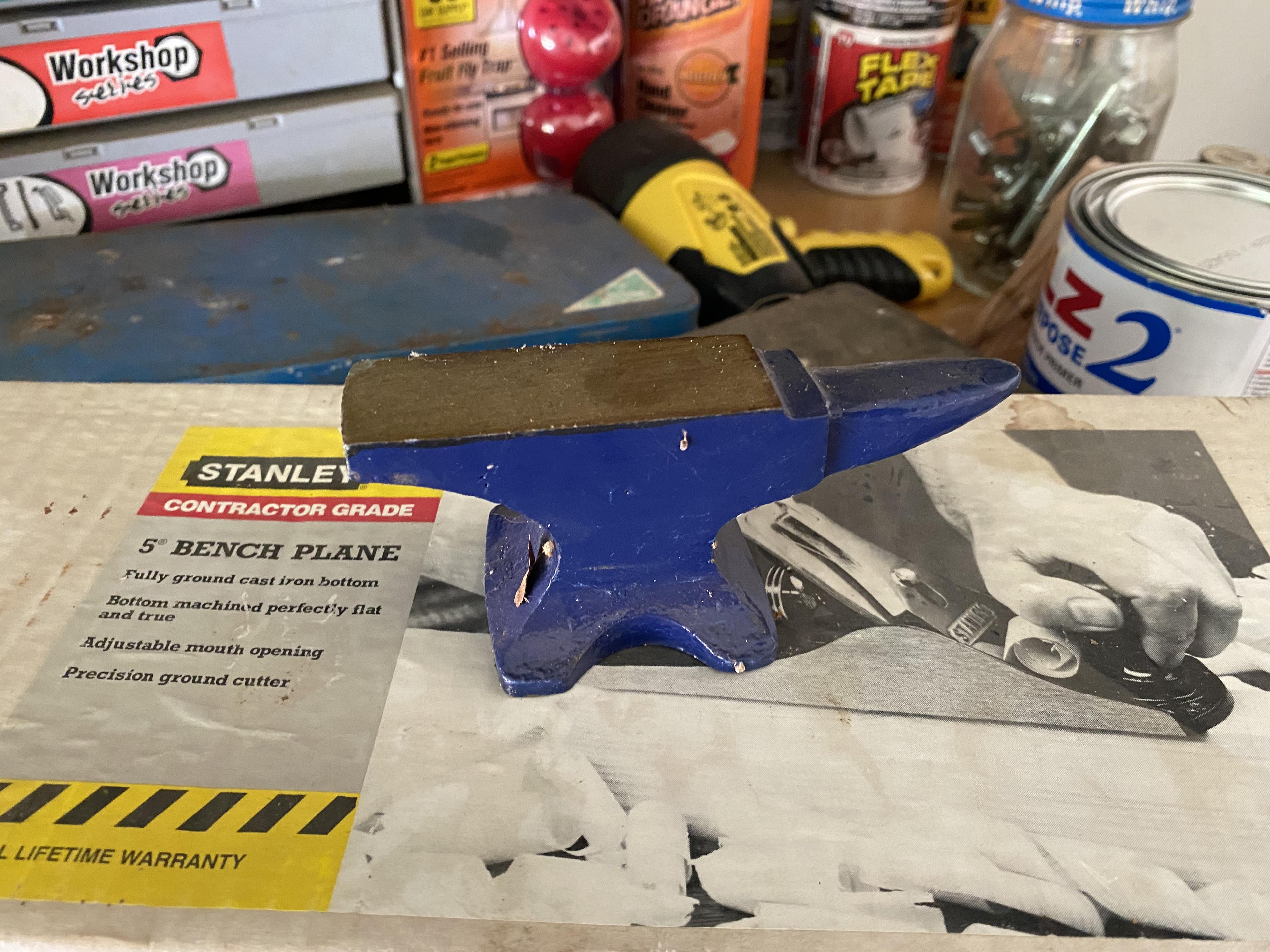 Items on right side of tool bench including anvil, plane in box