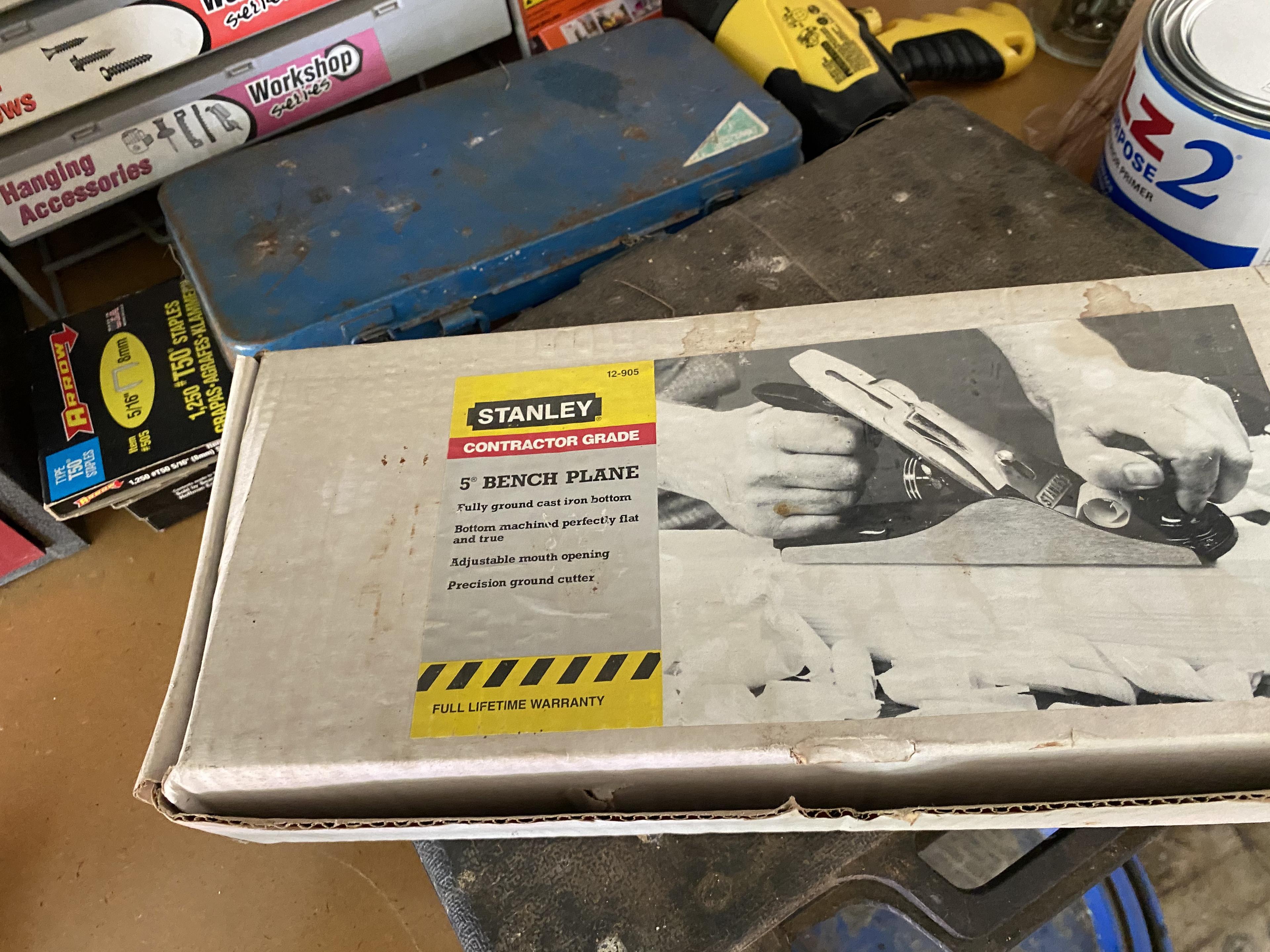 Items on right side of tool bench including anvil, plane in box