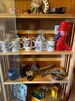 Contents of glass display cabinet, Las Vegas items, coffee mugs, bird clock, belt buckle, ashtrays