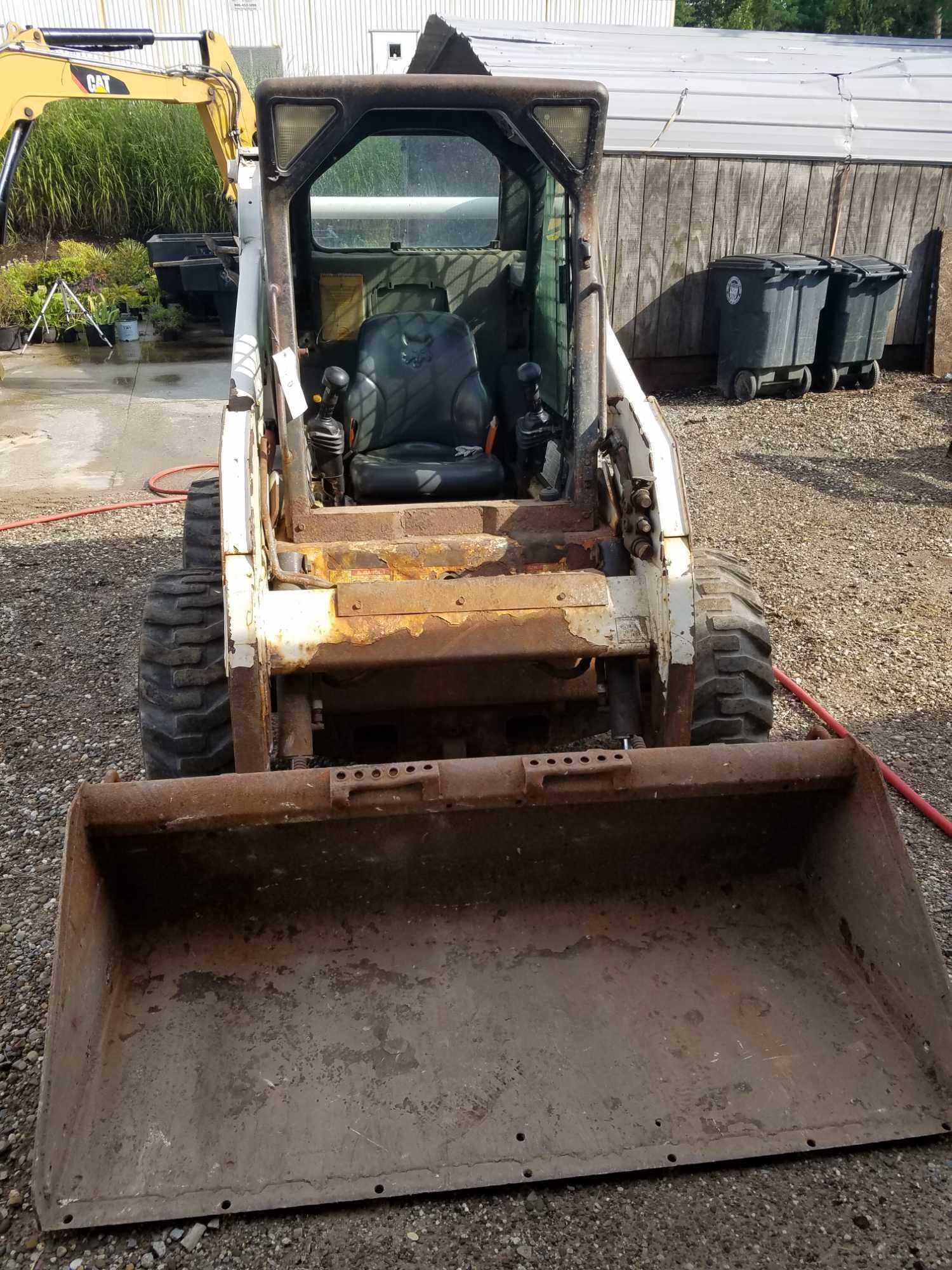 Bobcat S185 skid steer, diesel, and material bucket, 2,216 hours, spare tire