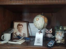 Bookcase with National Geographic DVDs, globe, lamp, picture frames and fan