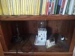 Bookcase with National Geographic DVDs, globe, lamp, picture frames and fan