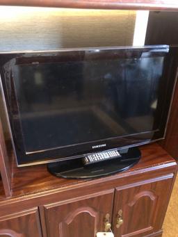 Entertainment center with Samsung TV, small fisher speakers and fan