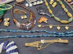 Lot of plastic bangles, chinky tiger eyes necklace, celluloid hair combs brooches and more