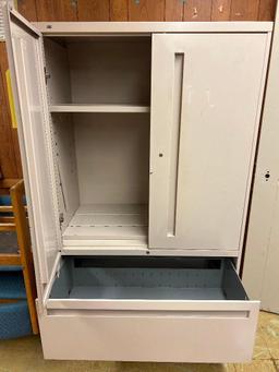 Tan metal storage cabinet with drawers, one door is locked