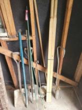 Group of flat shovels, wheelbarrow handles, solid tires, stakes