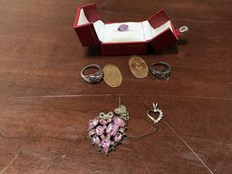 Red jewelry box with purple colored diamond shaped rock, Rings and pendants