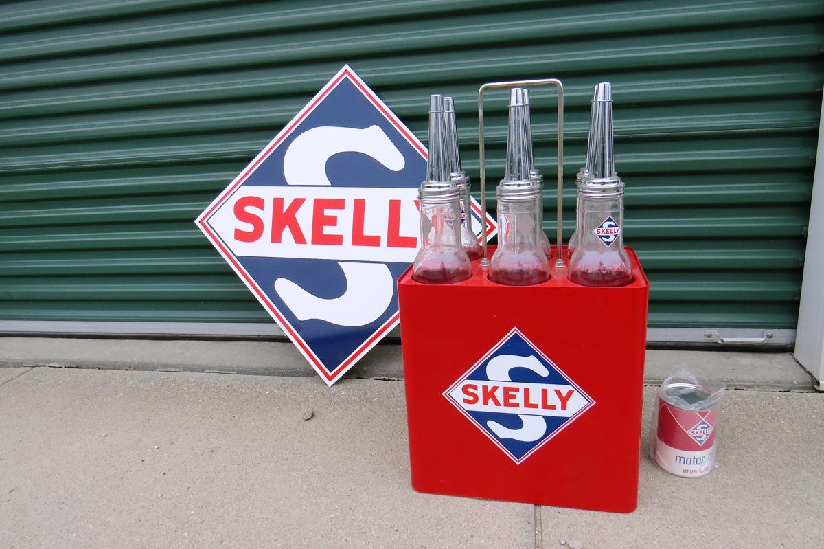 (1) Reproduction Skelly 6-Glass Jar Oil Bottles & Stand, (1) Reproduction Skelly Metal Sign & (1) Re