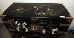 Ornate 6 drawer black lacquer dresser with brass hardware and stone accents.